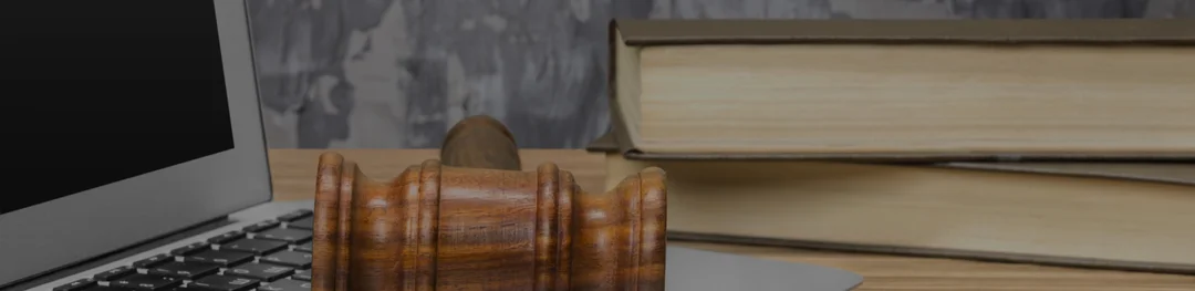 A wooden desk featuring a laptop and an open book, creating a cozy workspace atmosphere.