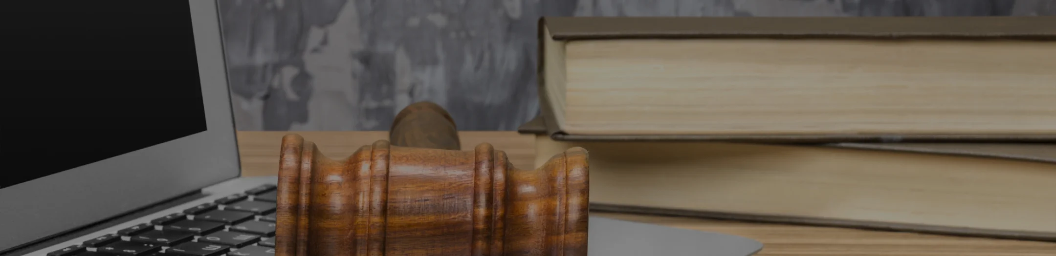 A wooden desk featuring a laptop and an open book, creating a cozy workspace atmosphere.