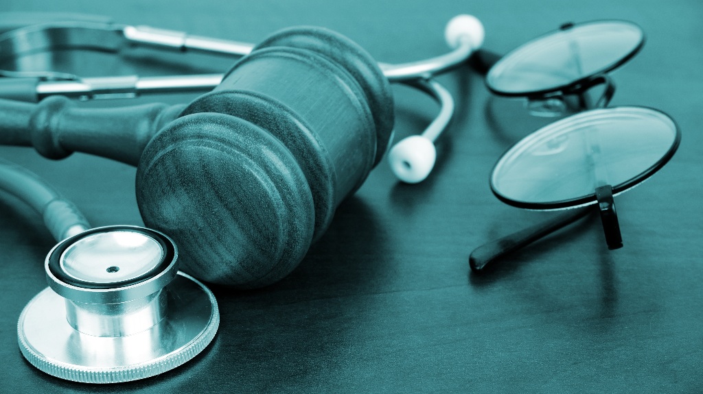 Judge gavel with stethoscope and glasses on the table