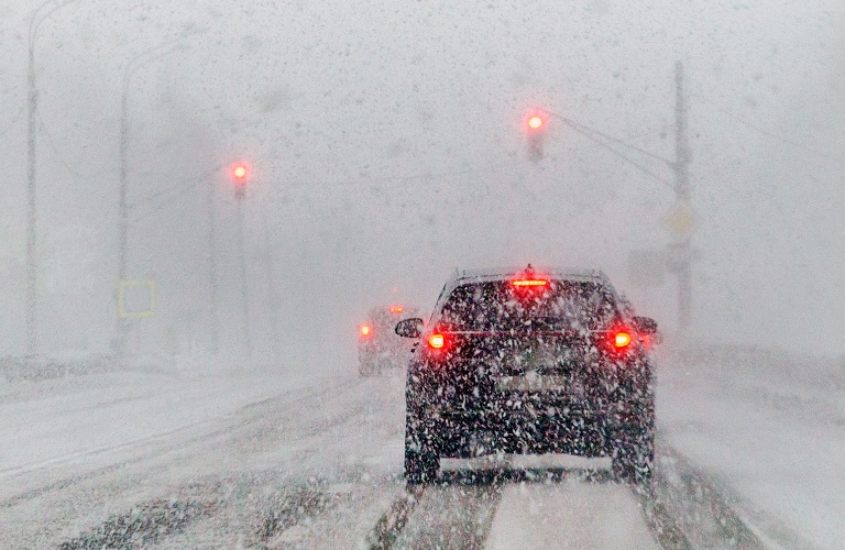 Cars driving on road in snowfall